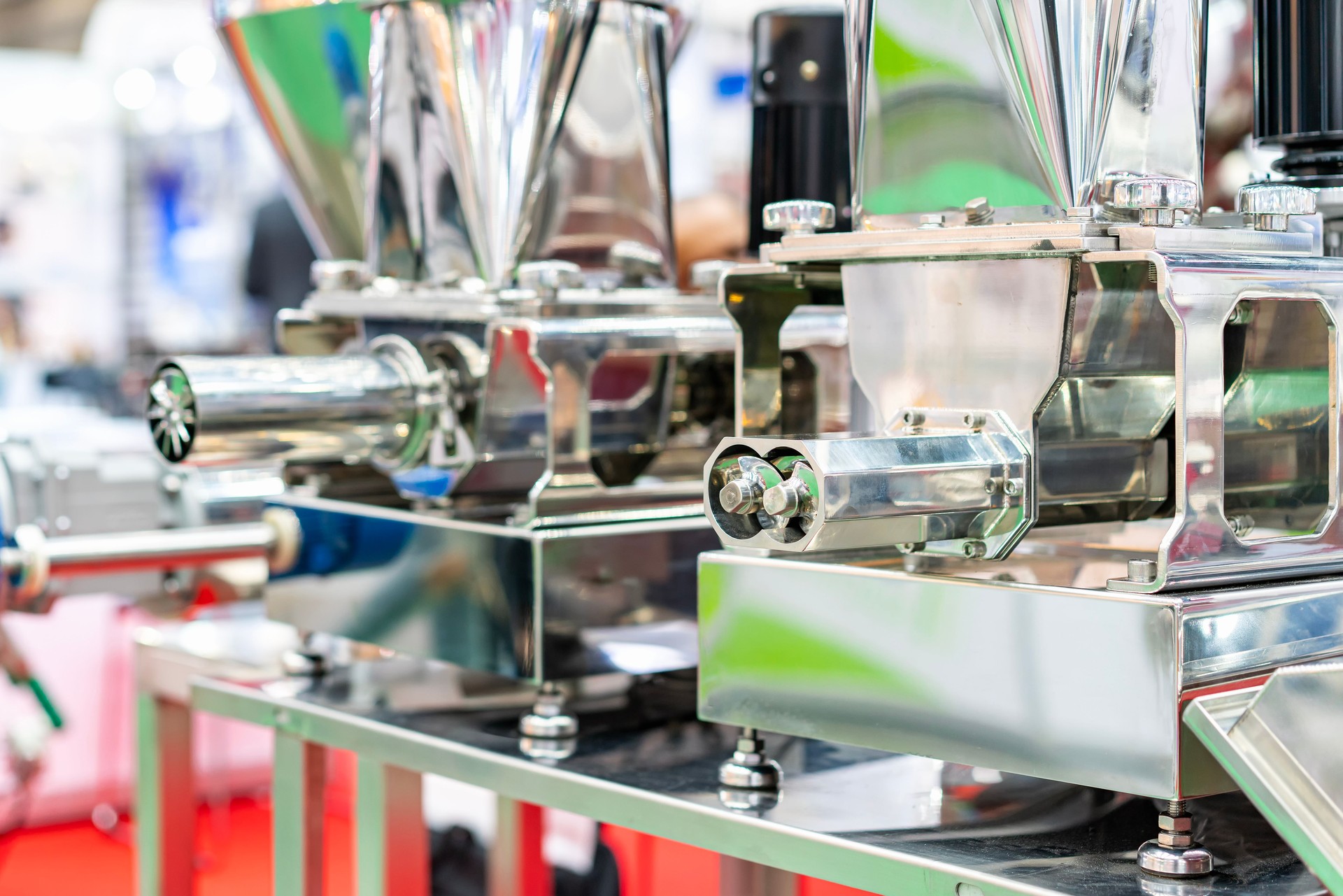 Close up stainless steel worm mincer screw at outlet tube or discharge gate of commercial grinder or masher machine for food industrial