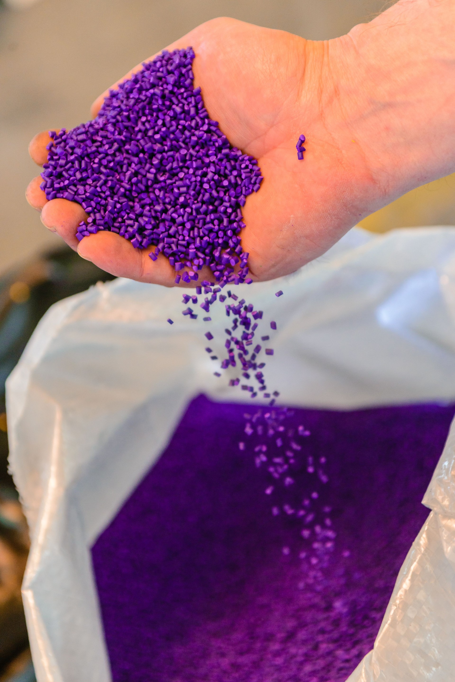 Colorful polymer masterbatch granules poured by hand isolated on white background for banner design product profile photo catalog industrial plastics company